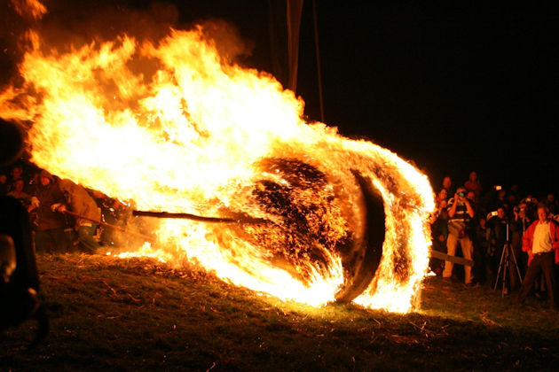 Abstoßen eines brennenden Rads beim Osterräderlauf in Lügde